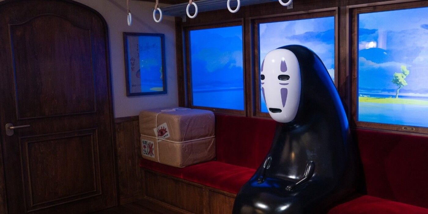 No Face sits calmly in the train attraction from Ghibli Park